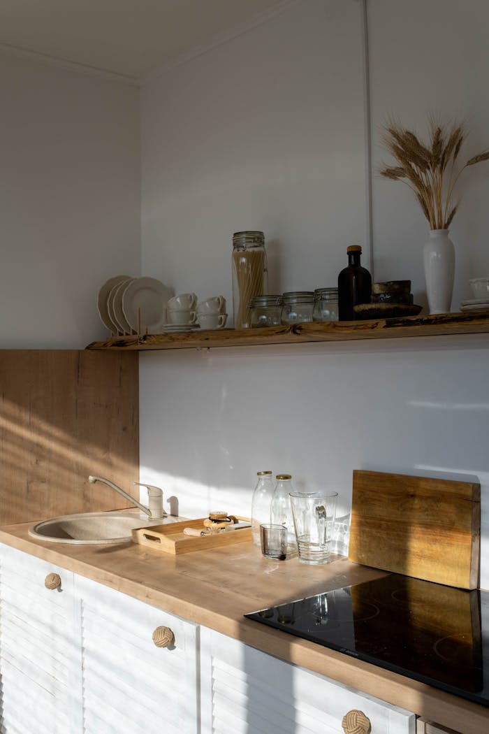 A sunlit minimalist kitchen interior with modern decor and wooden accents.
